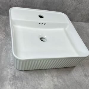 White ceramic sink on a gray concrete floor