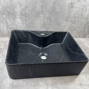Black marble sink on a gray concrete background