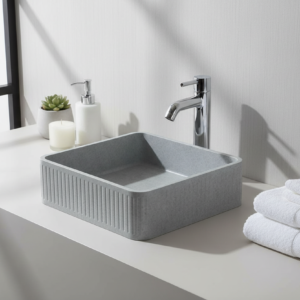 Gray stone sink with a circular drain hole on a white background